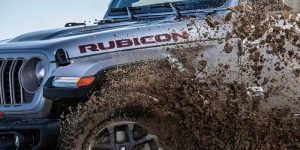 A 2024 Jeep Gladiator Rubicon driving through the mud