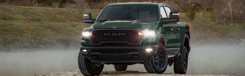 2026 RAM 1500 Rebel, a rugged green truck, parked in a natural outdoor setting