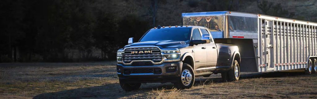 2026 RAM Heavy Duty truck towing a large trailer, set in a rugged outdoor environment